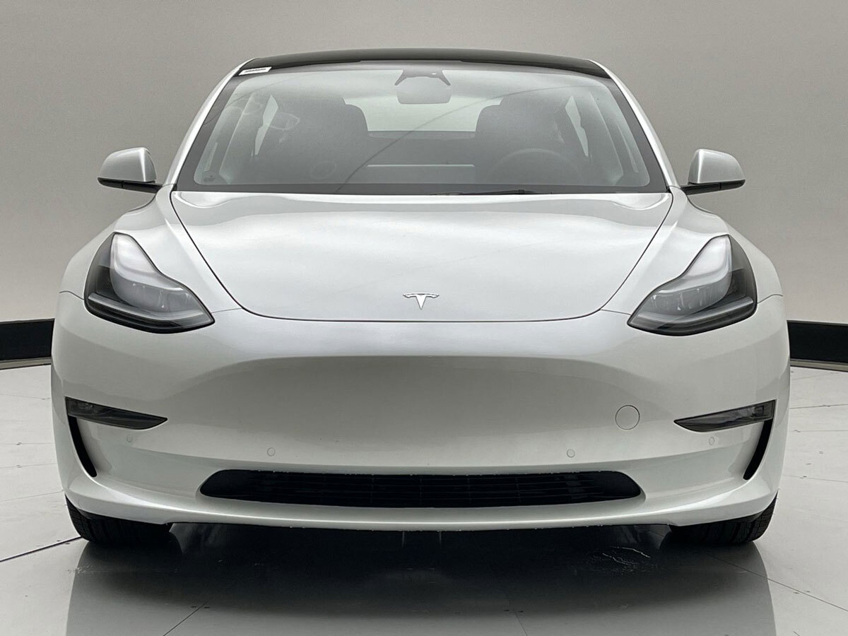 Front view of a white Tesla electric vehicle.